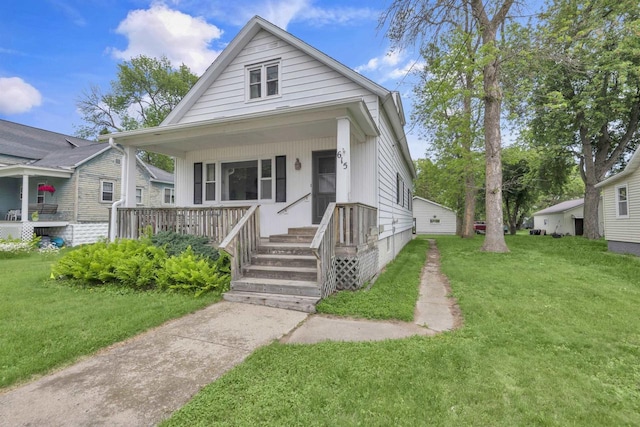 615 Ogden St, Marinette, WI 54143 - shotgun-style home featuring covered porch and a front yard