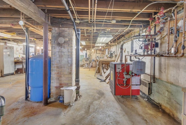 615 Ogden St, Marinette, WI 54143 - unfinished basement featuring a water pressure tank, a heating unit, and freestanding refrigerator