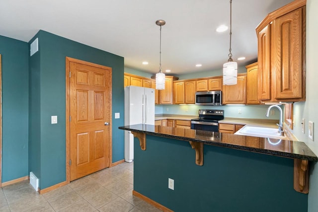 1601 Raspberry Ln, Mount Horeb, WI 53572 - kitchen with appliances with stainless steel finishes, a peninsula, recessed lighting, a kitchen bar, and light tile patterned flooring