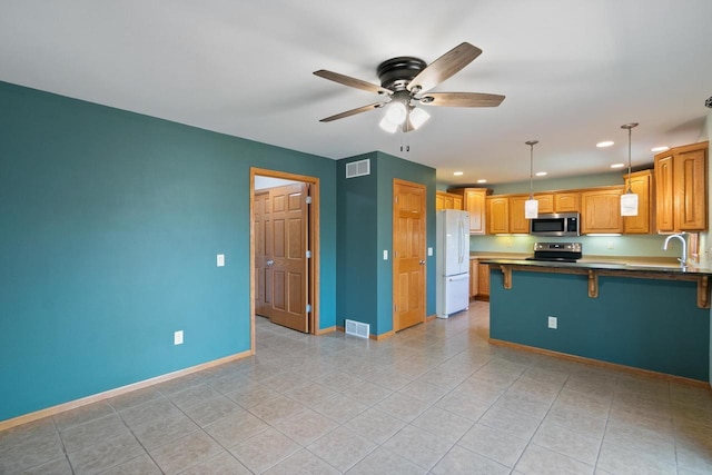 1601 Raspberry Ln, Mount Horeb, WI 53572 - kitchen featuring appliances with stainless steel finishes, a peninsula, light tile patterned floors, a ceiling fan, and recessed lighting