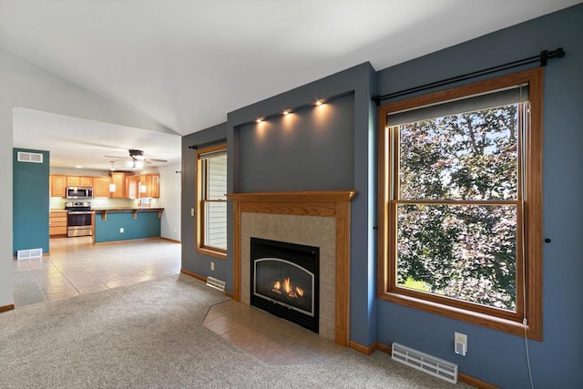 1601 Raspberry Ln, Mount Horeb, WI 53572 - unfurnished living room featuring vaulted ceiling, light carpet, a tile fireplace, light tile patterned floors, and ceiling fan