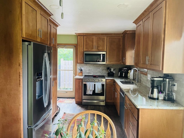 2266 Allerton Dr, Oshkosh, WI 54904 - kitchen featuring appliances with stainless steel finishes, light stone counters, brown cabinets, tasteful backsplash, and dark wood-style flooring