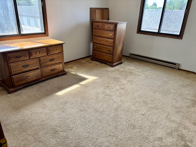 1712 Creek Rd Unit 202, West Bend, WI 53090 - bedroom with baseboard heating, multiple windows, and light carpet