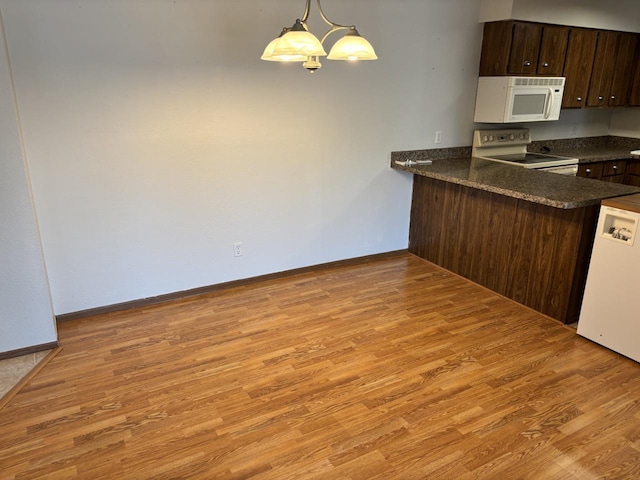 1712 Creek Rd Unit 202, West Bend, WI 53090 - kitchen featuring white appliances, dark countertops, light wood-type flooring, dark brown cabinets, and a peninsula