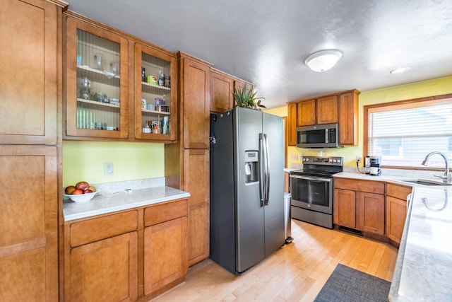 1508 Pearson St, Wausau, WI 54401 - kitchen featuring stainless steel appliances, brown cabinetry, and light wood finished floors