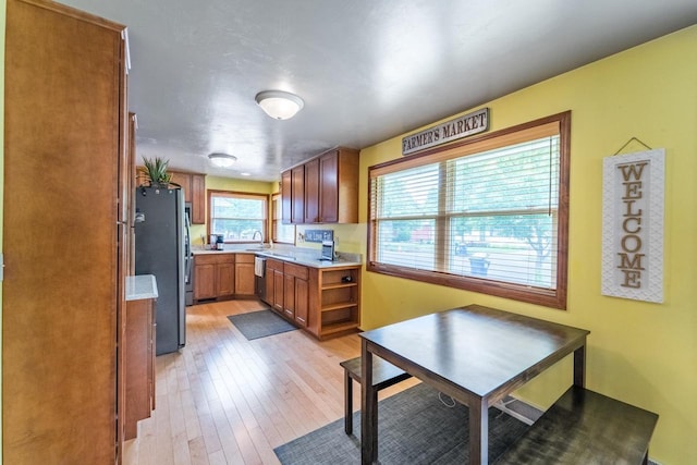 1508 Pearson St, Wausau, WI 54401 - kitchen with brown cabinets, appliances with stainless steel finishes, light wood-style floors, light countertops, and open shelves