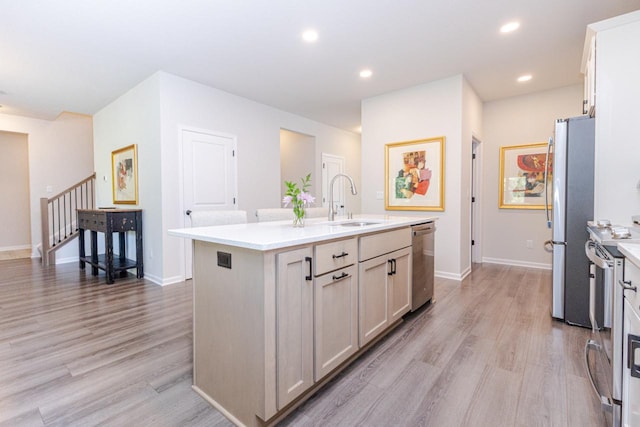 310 Paradise Ct, Hartland, WI 53029 - kitchen with appliances with stainless steel finishes, an island with sink, light wood-style flooring, light countertops, and recessed lighting