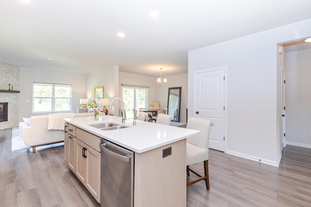 310 Paradise Ct, Hartland, WI 53029 - kitchen with dishwasher, open floor plan, a kitchen breakfast bar, an island with sink, and light wood-style floors