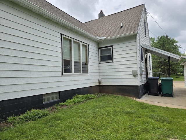 131 Crestview Ln, Nekoosa, WI 54457 - view of property exterior with a chimney, a yard, roof with shingles, and a patio area
