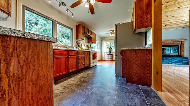 N2493 Kunz Rd, Fort Atkinson, WI 53538 - kitchen with a ceiling fan, stainless steel range oven, under cabinet range hood, and stone counters