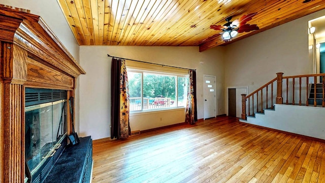 N2493 Kunz Rd, Fort Atkinson, WI 53538 - unfurnished living room with lofted ceiling, wood-type flooring, a fireplace with raised hearth, ceiling fan, and wood ceiling