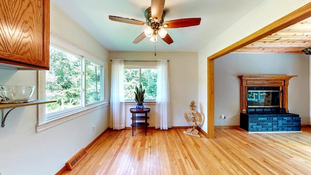 N2493 Kunz Rd, Fort Atkinson, WI 53538 - living area featuring light wood-type flooring, a ceiling fan, and a glass covered fireplace