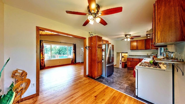 N2493 Kunz Rd, Fort Atkinson, WI 53538 - kitchen with freestanding refrigerator, white range with gas stovetop, ceiling fan, dark wood finished floors, and light countertops
