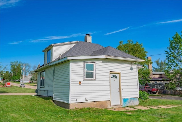 500 2nd Ave, Hollandale, WI 53544 - rear view of house featuring a lawn, a chimney, and a shingled roof