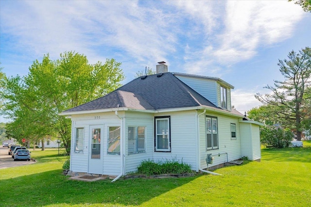 500 2nd Ave, Hollandale, WI 53544 - rear view of house featuring a chimney, a yard, and roof with shingles