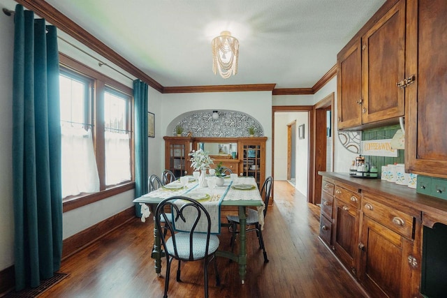 168 14th St, Fond Du Lac, WI 54935 - dining area featuring dark wood finished floors, ornamental molding, and a chandelier