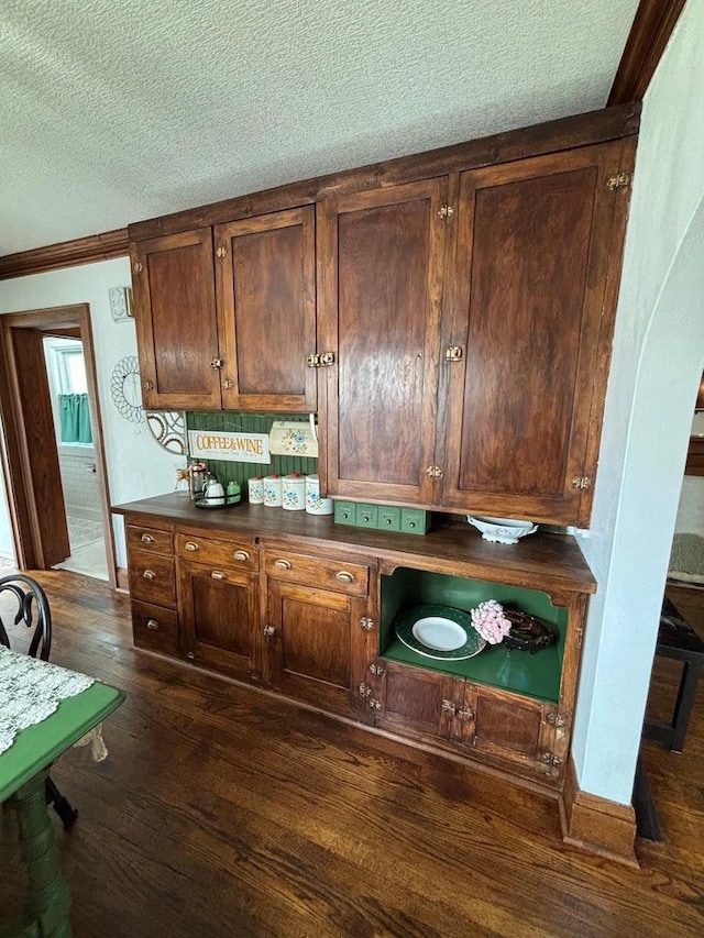168 14th St, Fond Du Lac, WI 54935 - kitchen featuring a textured ceiling, dark wood-style flooring, dark countertops, and ornamental molding