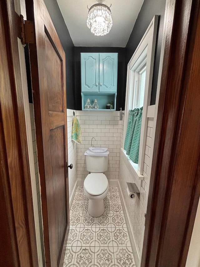 168 14th St, Fond Du Lac, WI 54935 - bathroom featuring tile patterned floors, a chandelier, a wainscoted wall, and tile walls