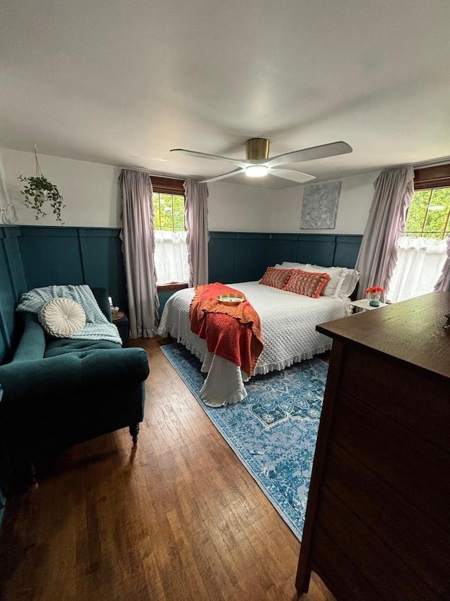 168 14th St, Fond Du Lac, WI 54935 - bedroom featuring wood finished floors, multiple windows, wainscoting, and a ceiling fan