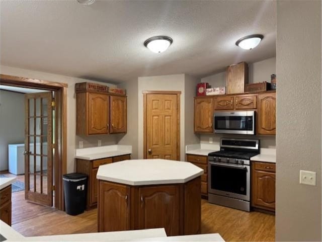 2779 250th Ave, Saint Croix Falls, WI 54024 - kitchen featuring appliances with stainless steel finishes, light wood-style floors, light countertops, and a kitchen island