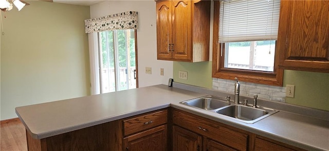 2931 148th Ave, Bloomer, WI 54724 - kitchen featuring a peninsula, brown cabinets, backsplash, and wood finished floors