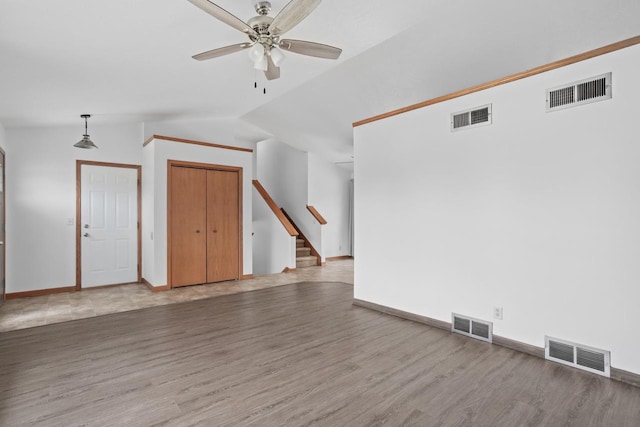 1335 Terapin Trl, Janesville, WI 53545 - unfurnished room featuring ceiling fan, wood finished floors, vaulted ceiling, and stairway