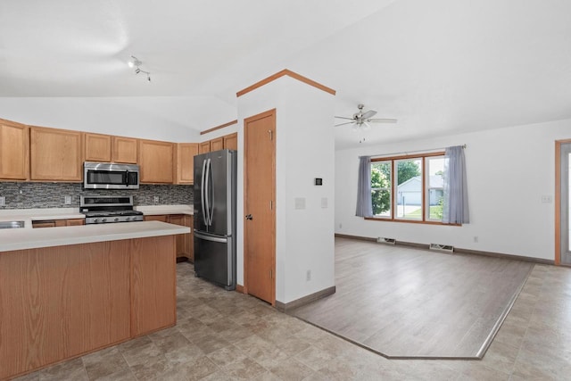 1335 Terapin Trl, Janesville, WI 53545 - kitchen featuring stainless steel appliances, vaulted ceiling, light countertops, open floor plan, and backsplash