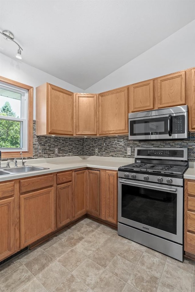 1335 Terapin Trl, Janesville, WI 53545 - kitchen with stainless steel appliances, lofted ceiling, tasteful backsplash, and light countertops