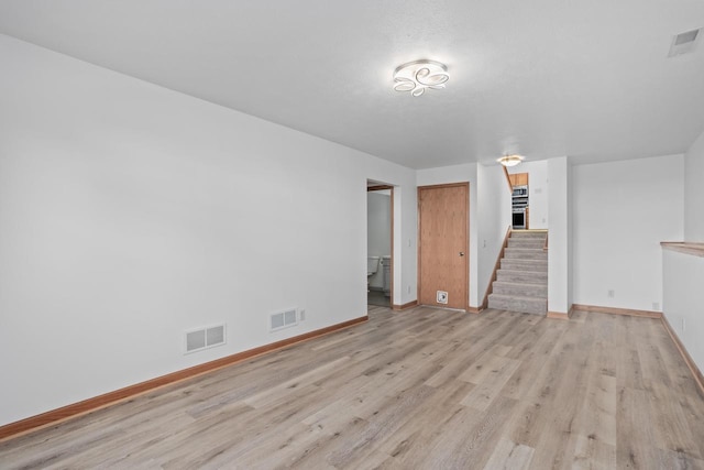 1335 Terapin Trl, Janesville, WI 53545 - unfurnished living room with stairway and light wood-style flooring