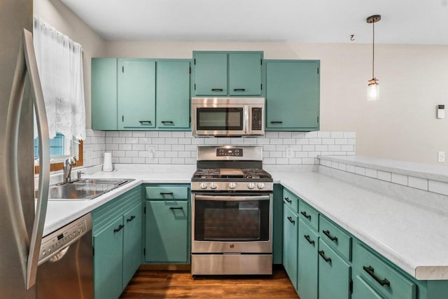 1602 Golden Oak Ln, Madison, WI 53711 - kitchen with appliances with stainless steel finishes, light countertops, backsplash, dark wood-style floors, and pendant lighting