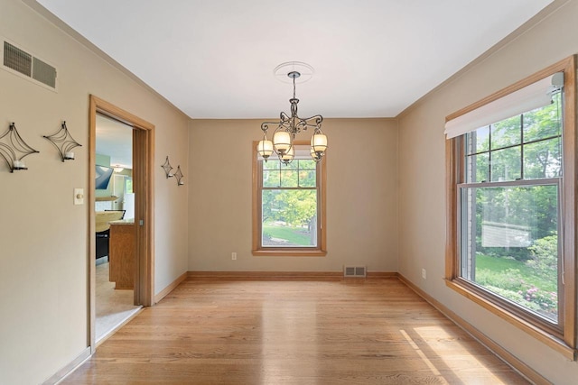 1060 Hawthorne Ln, Brookfield, WI 53005 - spare room with healthy amount of natural light, a chandelier, and light wood-type flooring