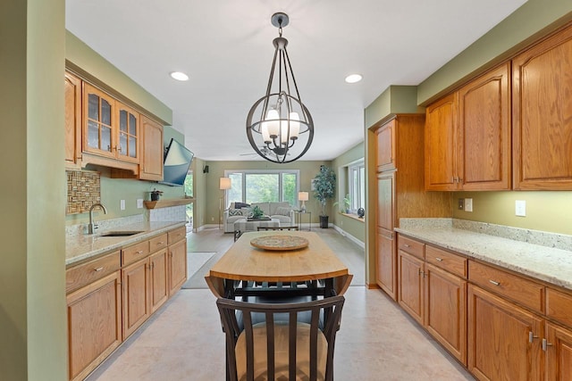 1060 Hawthorne Ln, Brookfield, WI 53005 - kitchen featuring a chandelier, light stone countertops, glass insert cabinets, decorative light fixtures, and open floor plan