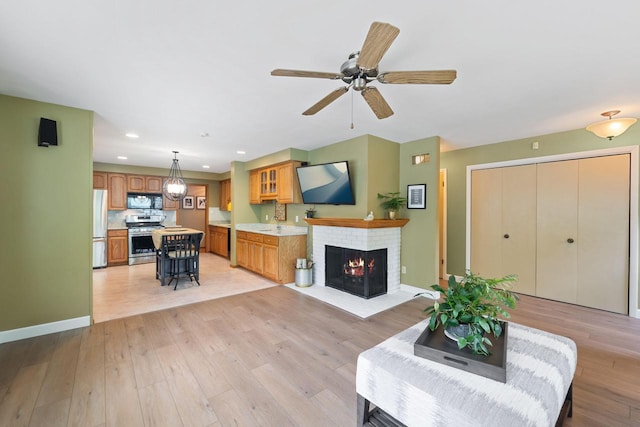1060 Hawthorne Ln, Brookfield, WI 53005 - living area with light wood finished floors, a fireplace, a ceiling fan, and recessed lighting