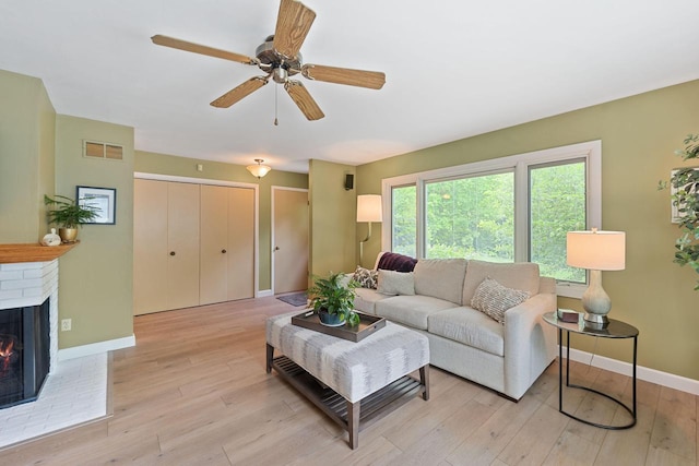 1060 Hawthorne Ln, Brookfield, WI 53005 - living room featuring light wood-type flooring, a brick fireplace, and ceiling fan