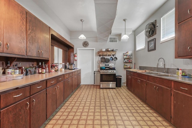 210 N 2nd St, Palmyra, WI 53156 - kitchen with stainless steel range with gas stovetop, light flooring, light countertops, and decorative light fixtures