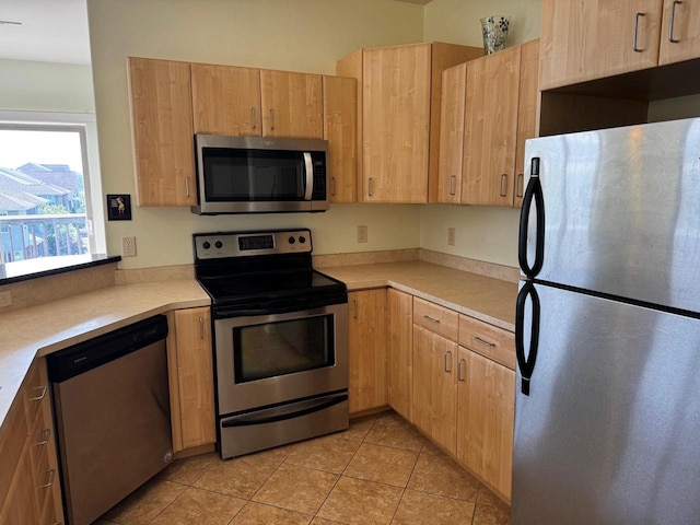 5196 Sassafras Dr Unit 313, Fitchburg, WI 53711 - kitchen featuring appliances with stainless steel finishes, light brown cabinetry, light countertops, and light tile patterned flooring