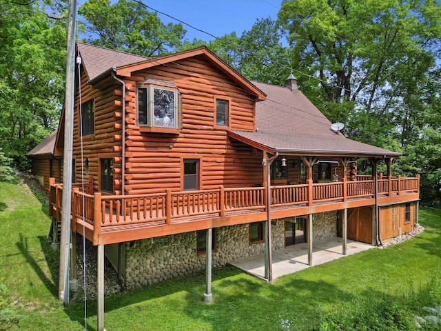 5633 Contour Rd, Waterford, WI 53185 - rear view of house with log exterior, a patio, a lawn, a deck, and a shingled roof