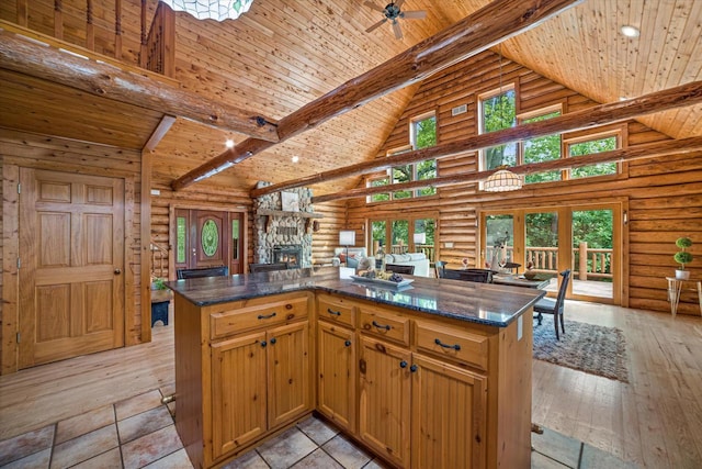 5633 Contour Rd, Waterford, WI 53185 - kitchen featuring log walls, high vaulted ceiling, a stone fireplace, a wooden ceiling with exposed beams, and open floor plan