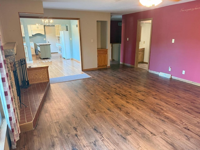 N72W14281 Good Hope Rd, Menomonee Falls, WI 53051 - unfurnished living room with wood finished floors, a chandelier, and a fireplace with raised hearth