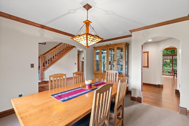 4570 Stoney Creek Rd, West Bend, WI 53095 - dining room with arched walkways, crown molding, stairs, and wood finished floors
