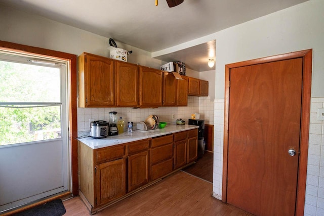 2110 54th St, Kenosha, WI 53140 - kitchen featuring light countertops, light wood-type flooring, brown cabinets, and tasteful backsplash