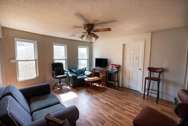 2110 54th St, Kenosha, WI 53140 - living room featuring wood finished floors, a ceiling fan, a textured ceiling, and wooden walls
