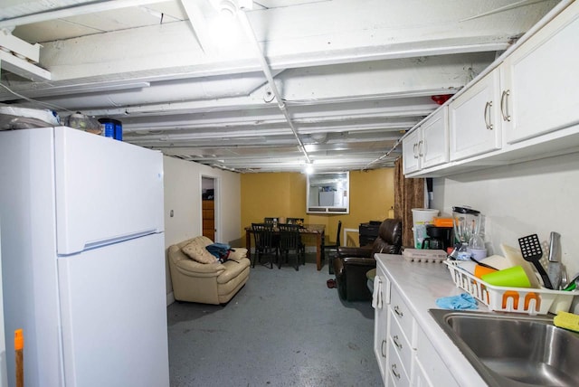 2110 54th St, Kenosha, WI 53140 - kitchen with freestanding refrigerator, white cabinets, light countertops, and concrete floors