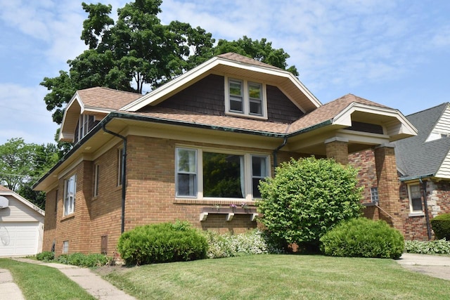 1032 Russet St, Racine, WI 53405 - view of front of home with brick siding, a front lawn, an outdoor structure, and roof with shingles