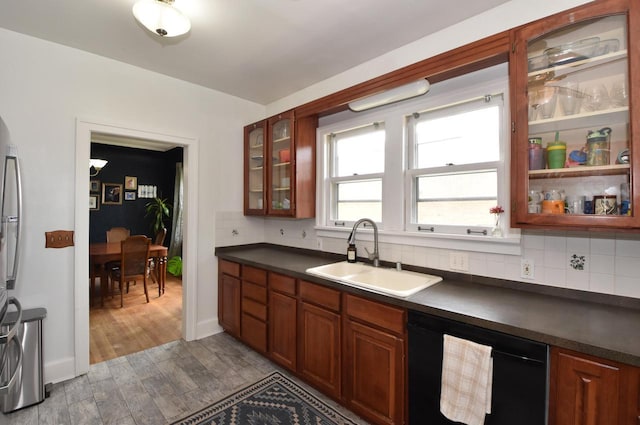 1032 Russet St, Racine, WI 53405 - kitchen featuring black dishwasher, dark countertops, wood finished floors, decorative backsplash, and glass insert cabinets