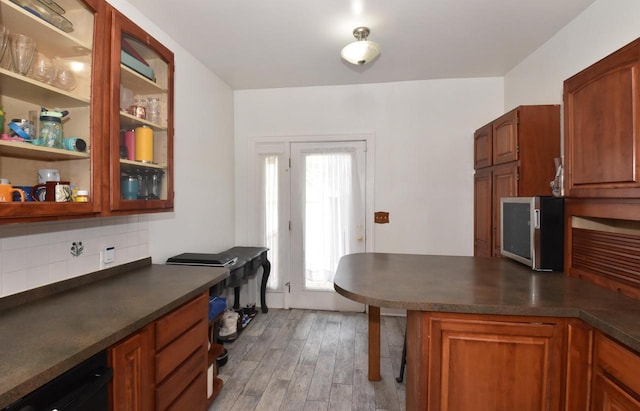 1032 Russet St, Racine, WI 53405 - kitchen with dark countertops, decorative backsplash, light wood finished floors, and a peninsula