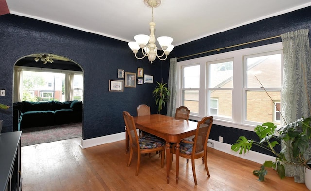 1032 Russet St, Racine, WI 53405 - dining area with a chandelier, wood finished floors, and an accent wall