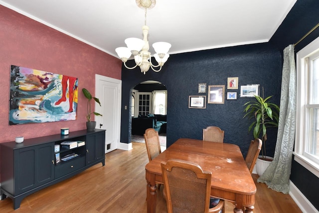 1032 Russet St, Racine, WI 53405 - dining area featuring arched walkways, a chandelier, an accent wall, healthy amount of natural light, and ornamental molding