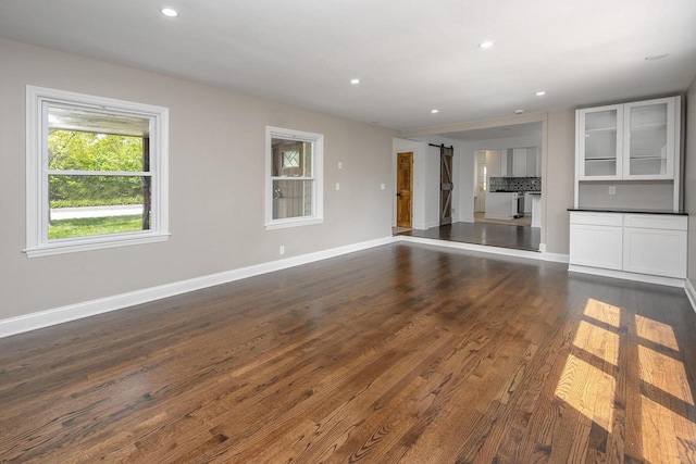 1120 N 124th St, Wauwatosa, WI 53226 - unfurnished living room with dark wood-style flooring, recessed lighting, and a barn door