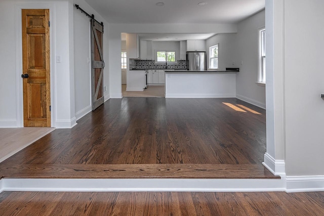 1120 N 124th St, Wauwatosa, WI 53226 - unfurnished living room with a barn door and wood finished floors